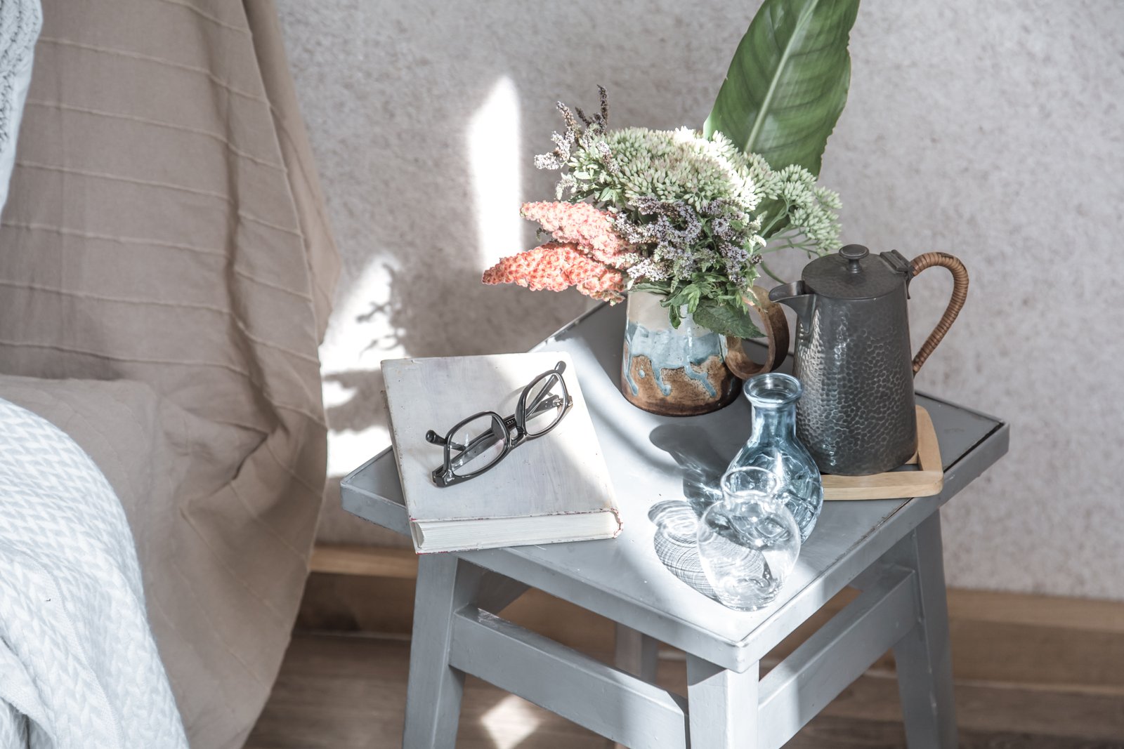 Bedside table with flowers and home accessories