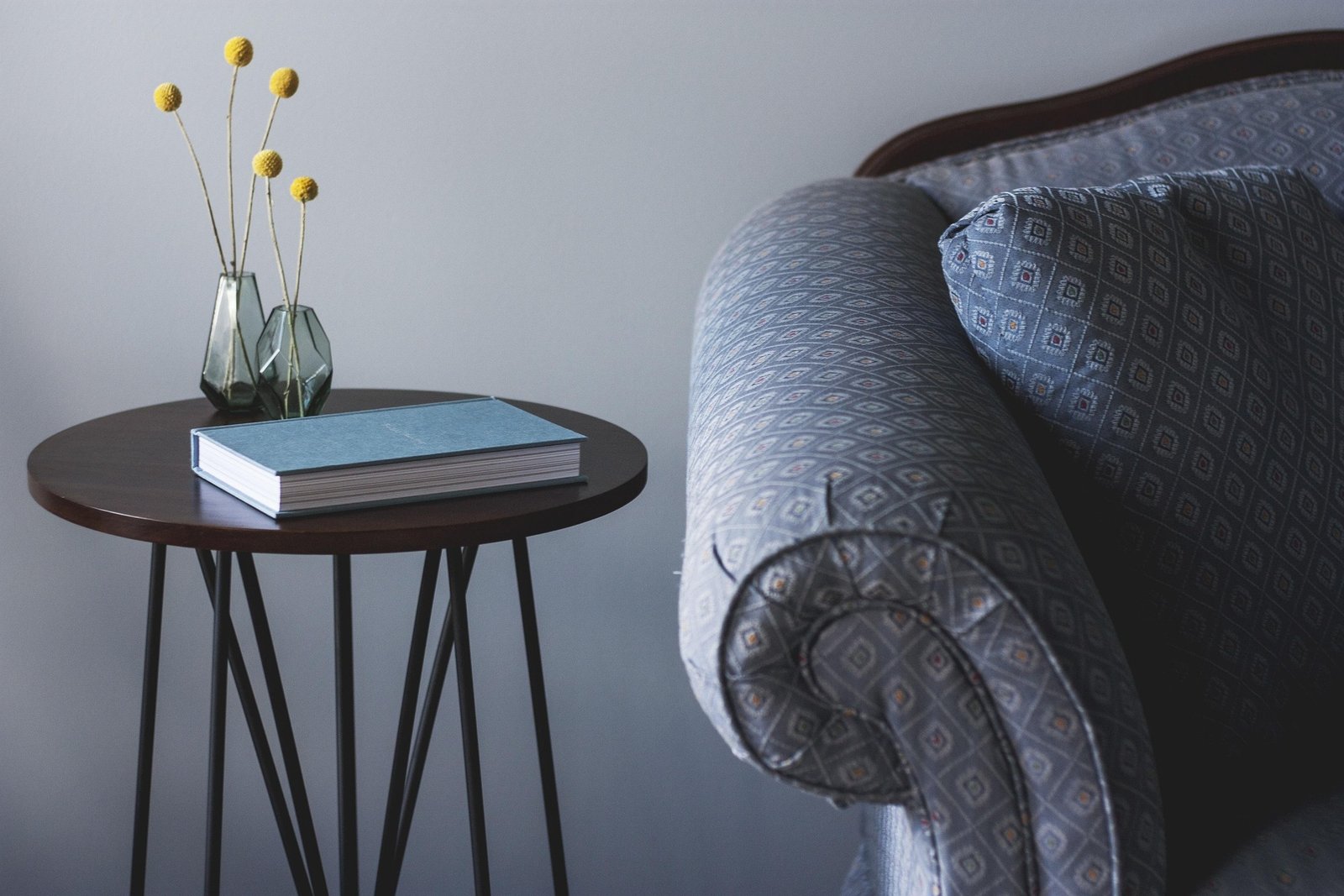 Walnut-toned side table beside a sofa